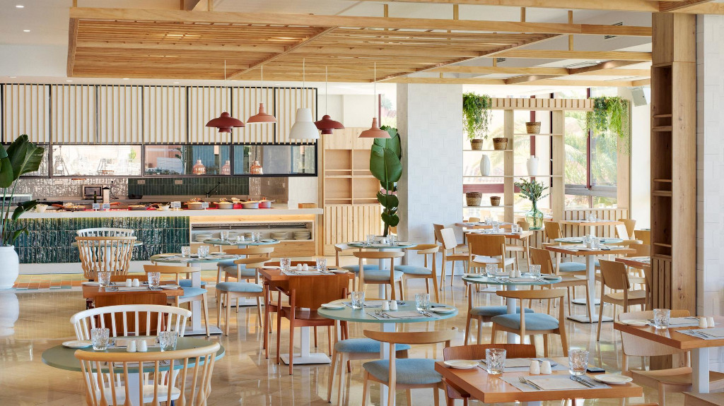 Restaurant lumineux avec chaises en bois et tables dressées à Tenerife.