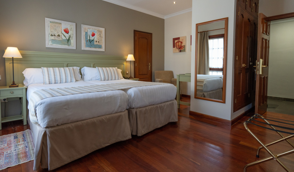 Chambre avec lit double, lampes de chevet, tableau et miroir à Tenerife.