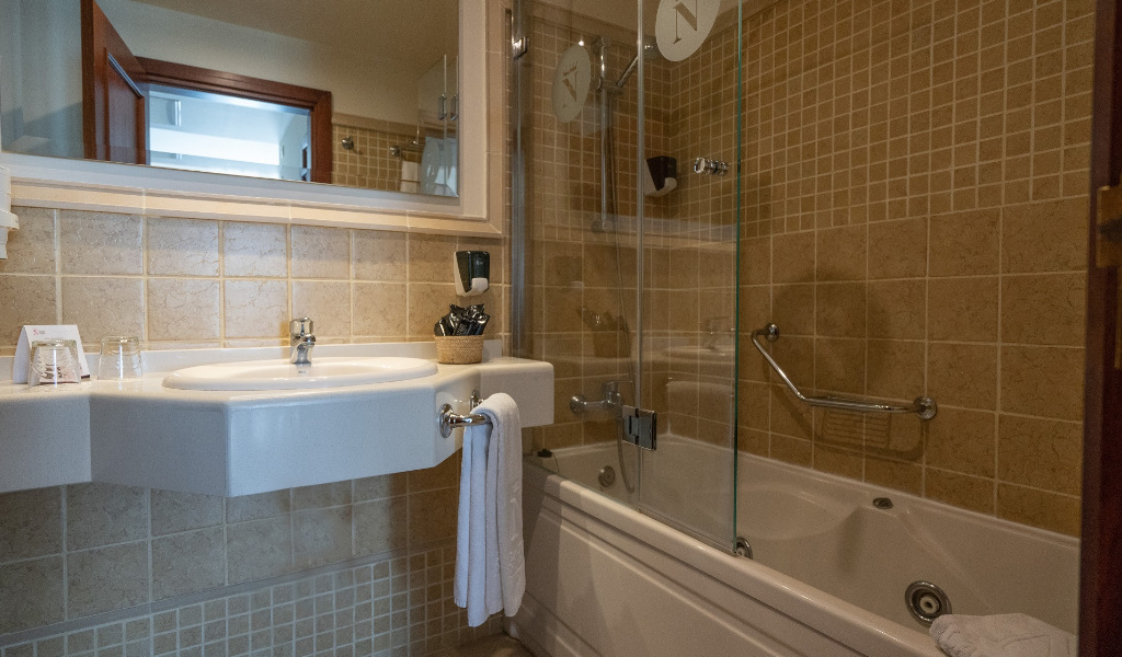 Salle de bain moderne avec lavabo, baignoire et accessoires à Tenerife.