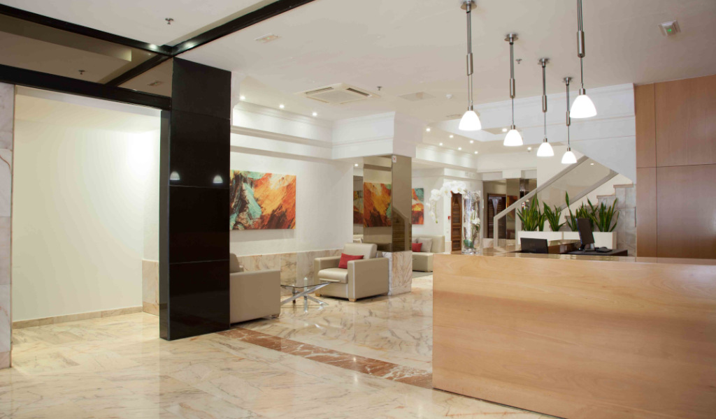 Réception moderne d'un hôtel à Tenerife avec plantes et tableaux colorés.