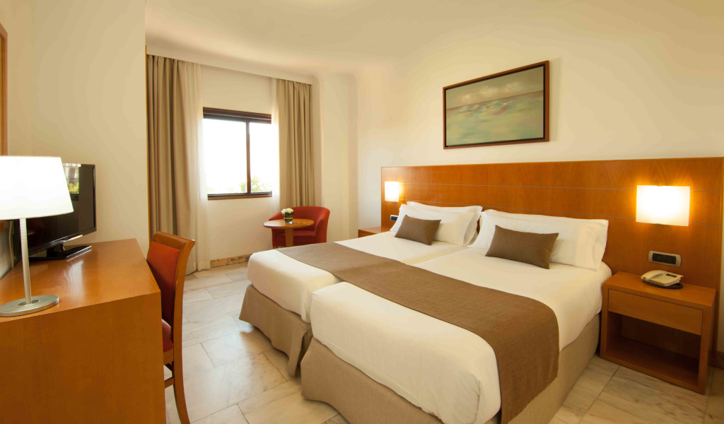Chambre d'hôtel avec deux lits simples, table et chaise à Tenerife.