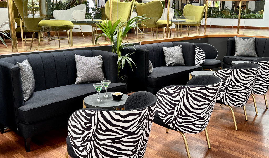 Salon élégant avec canapés noirs et chaises zèbre à Tenerife.