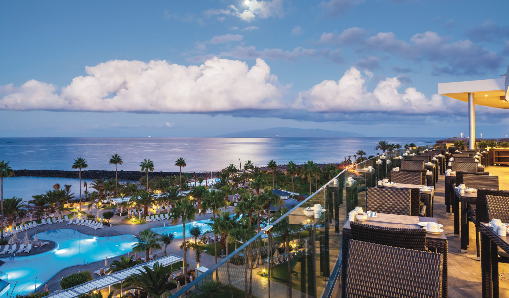 Terrasse de restaurant avec vue sur l'océan et piscines à Tenerife.