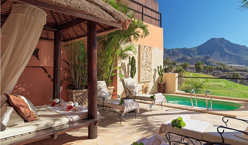 Terrasse avec transats et piscine surplombant montagnes à Tenerife.