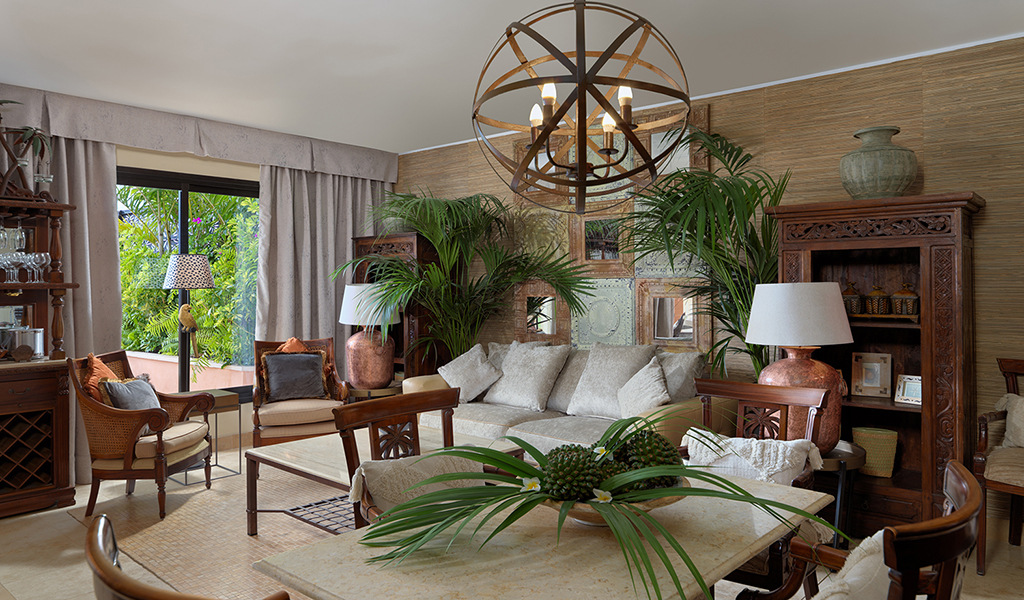 Salon élégant avec meubles en bois, plantes vertes et grande fenêtre vue Tenerife.