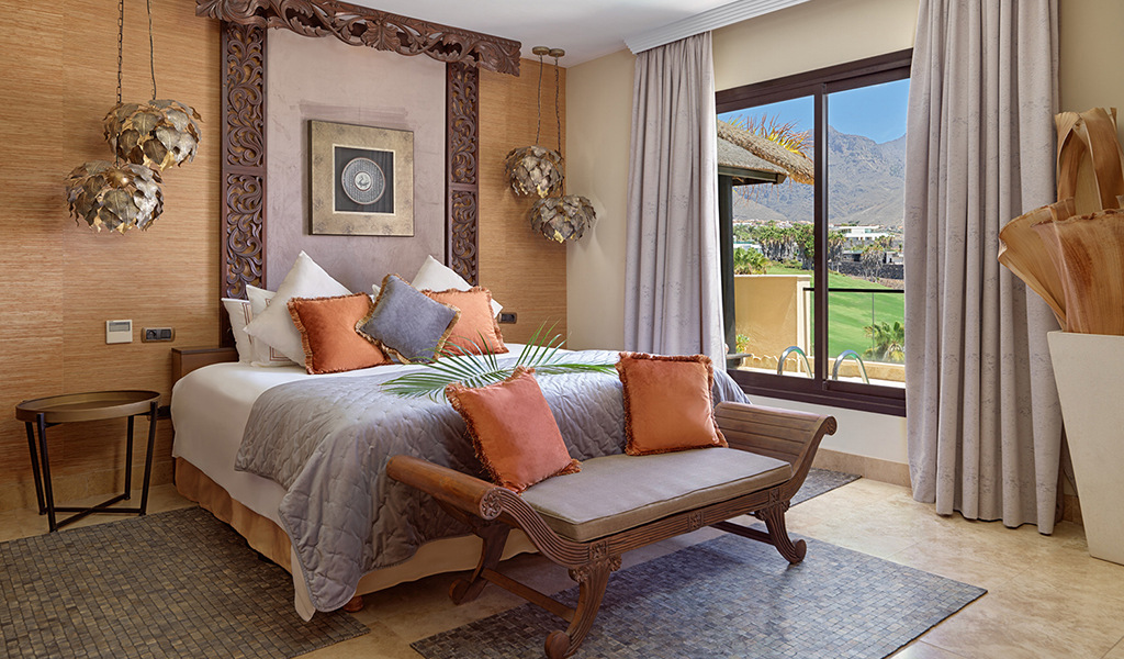 Chambre avec vue sur montagne à Tenerife, lit décoré de coussins.