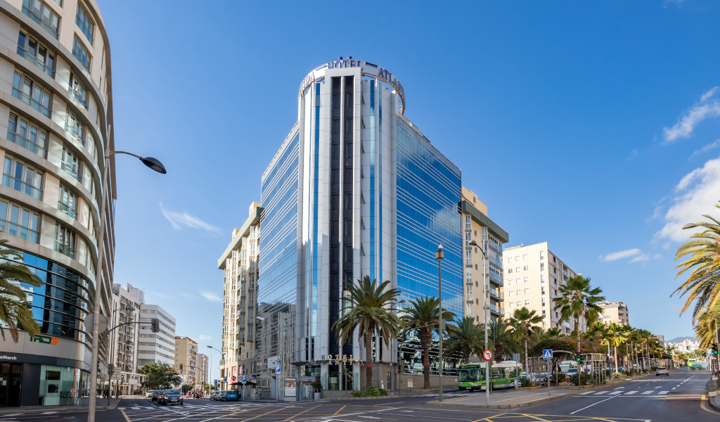 Bâtiment moderne et palmiers à Santa Cruz de Tenerife par temps ensoleillé.