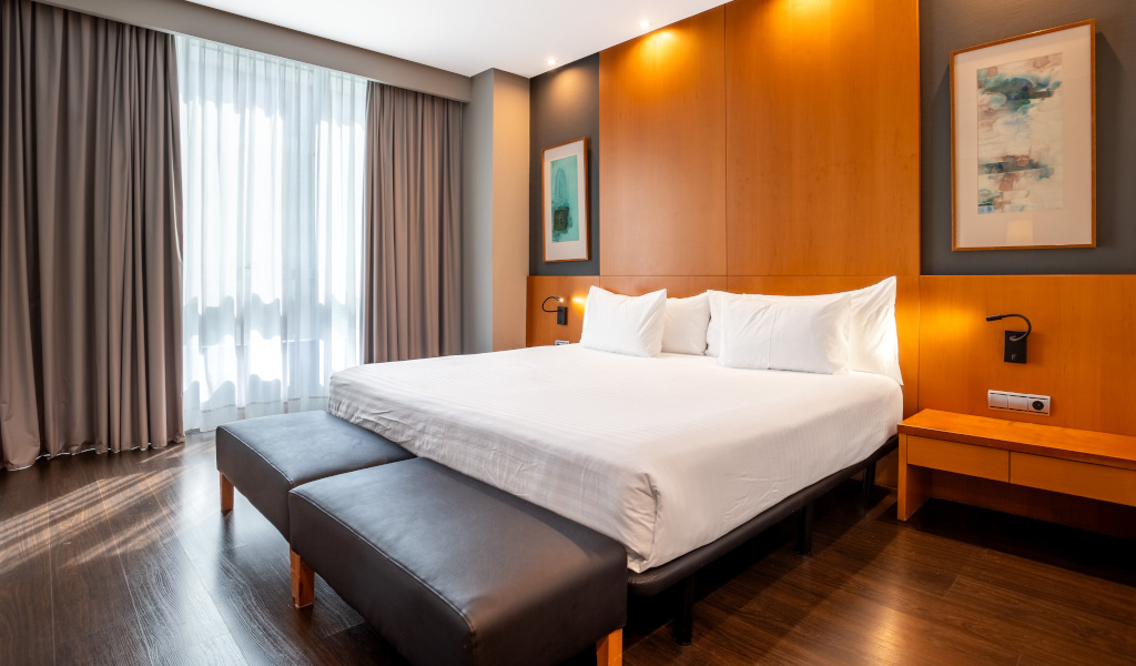 Chambre d'hôtel moderne à Tenerife avec lit double et lumière naturelle.