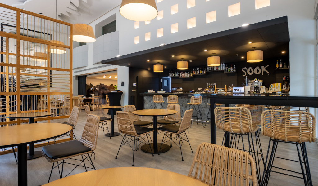 Espace intérieur du restaurant Sook à Tenerife avec tables et chaises en osier.