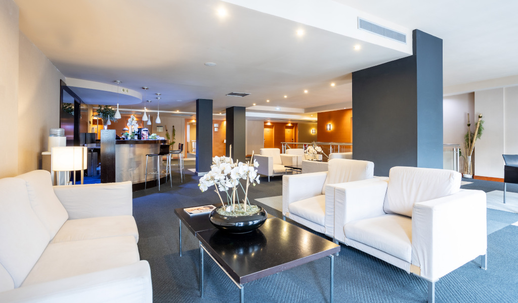 Salon moderne avec canapés blancs et bar en arrière-plan à Tenerife.