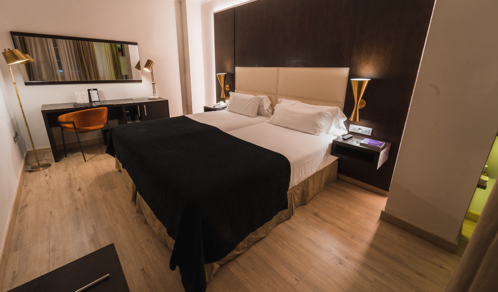 Chambre avec deux lits simples, bureau et lampes modernes à Tenerife.