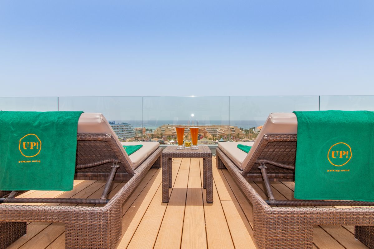 Chaises longues et boissons sur terrasse avec vue sur El Médano à Tenerife.