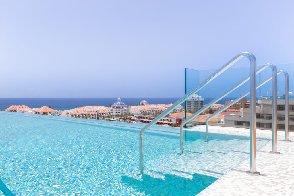 Piscine à débordement avec vue sur la mer et les toits à Tenerife.