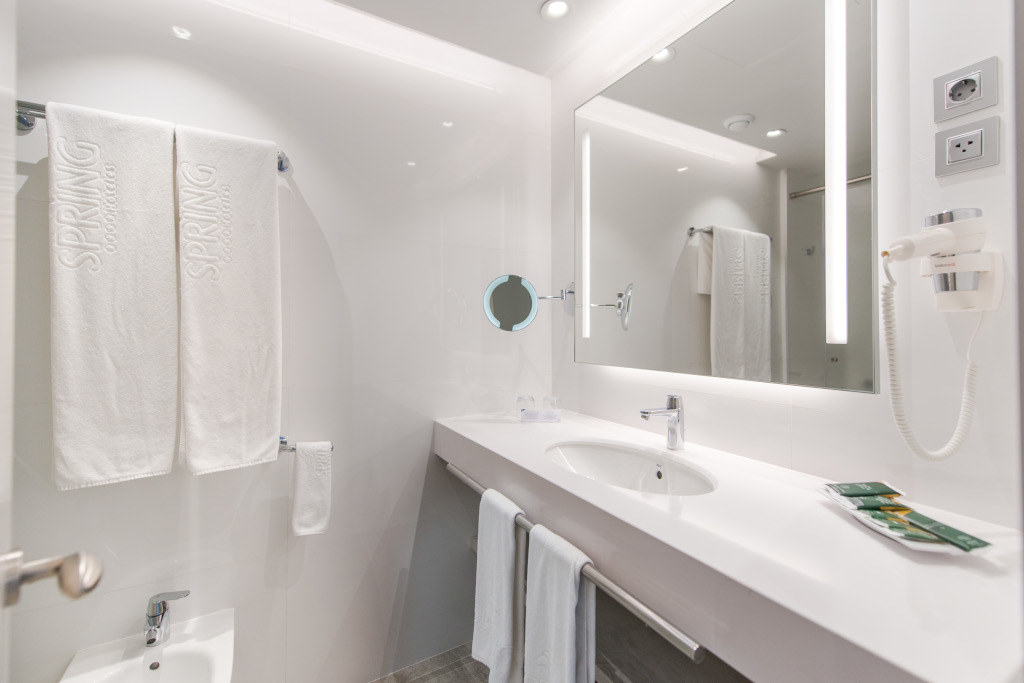 Salle de bain moderne à Tenerife avec serviettes SPRING blanches et miroir éclairé.