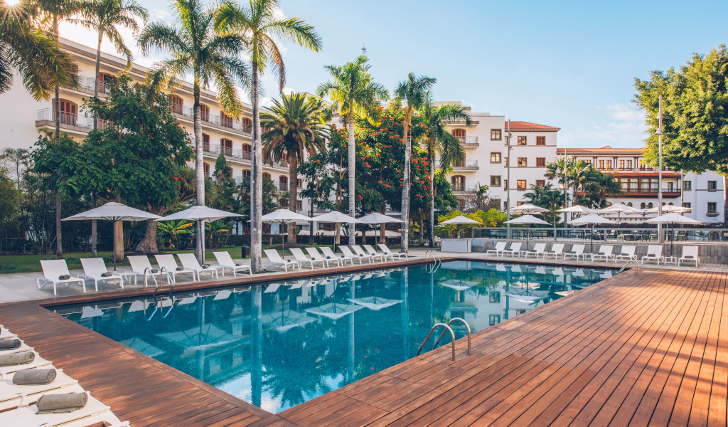 Piscine entourée de chaises longues et palmiers à Tenerife.