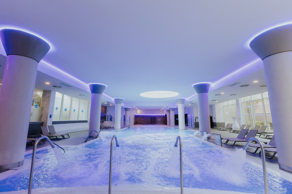 Piscine intérieure avec jets d'eau et chaises longues à Tenerife.