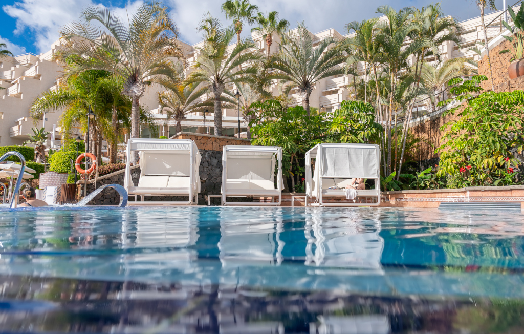 Piscine avec chaises longues et palmiers à Tenerife.