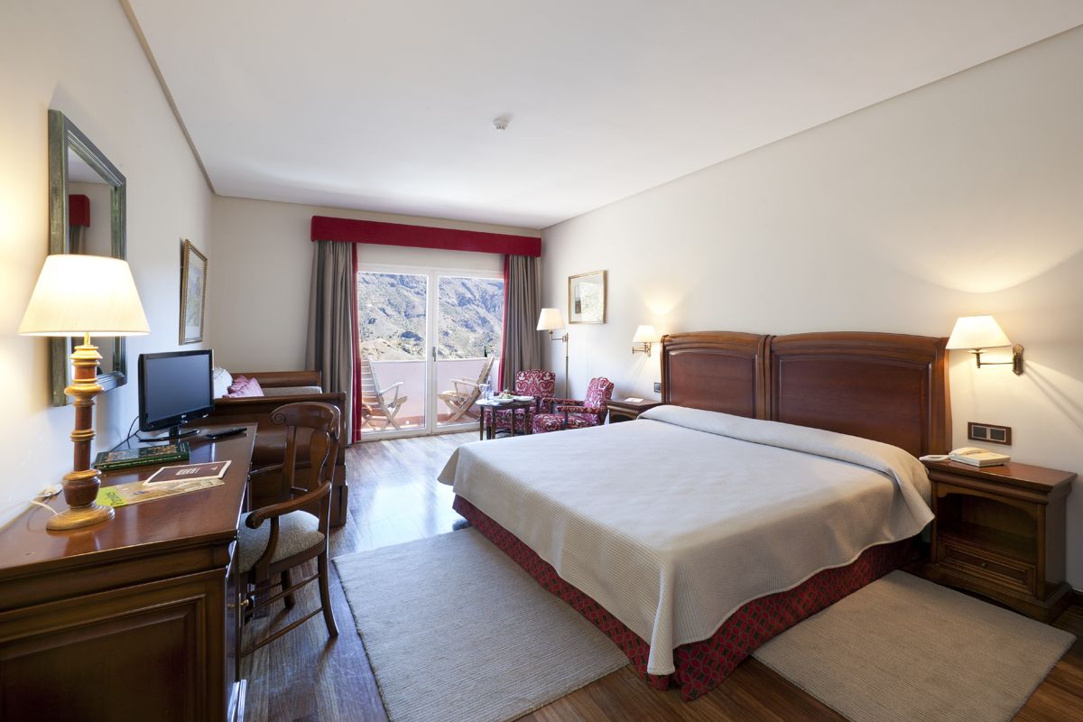 Chambre d'hôtel à Tenerife, lit double, vue sur la montagne par la fenêtre.