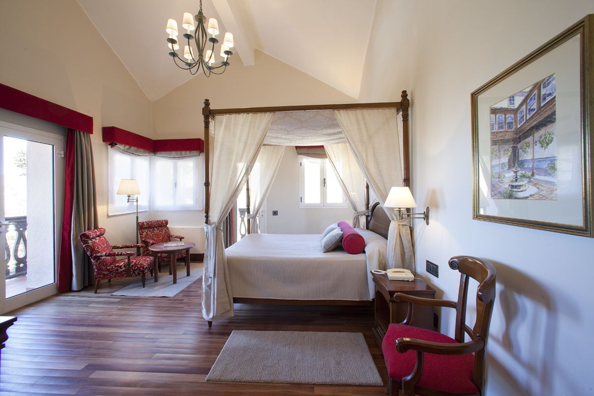 Chambre avec lit à baldaquin et fauteuils en bois à Tenerife.