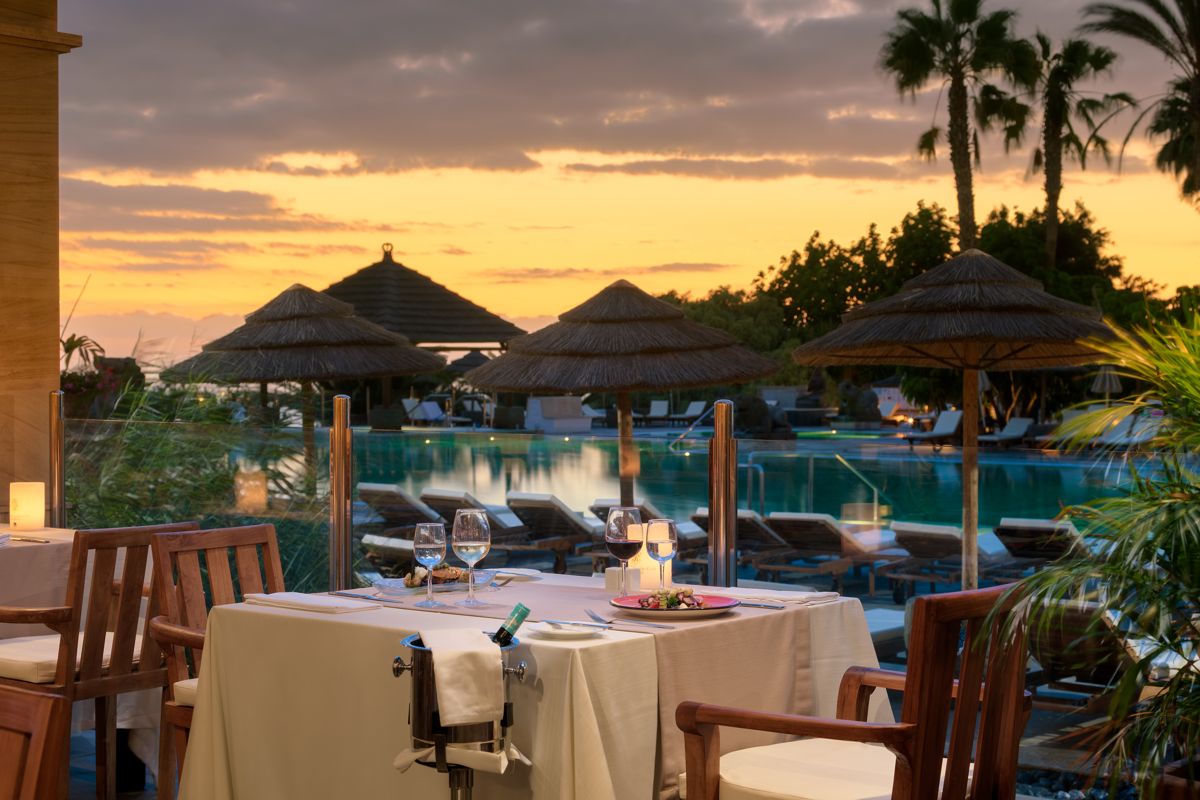 Table dressée devant piscine au coucher du soleil à Tenerife.