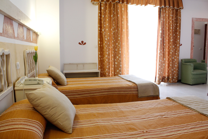 Deux lits simples avec couvre-lit orange dans une chambre lumineuse à Tenerife.