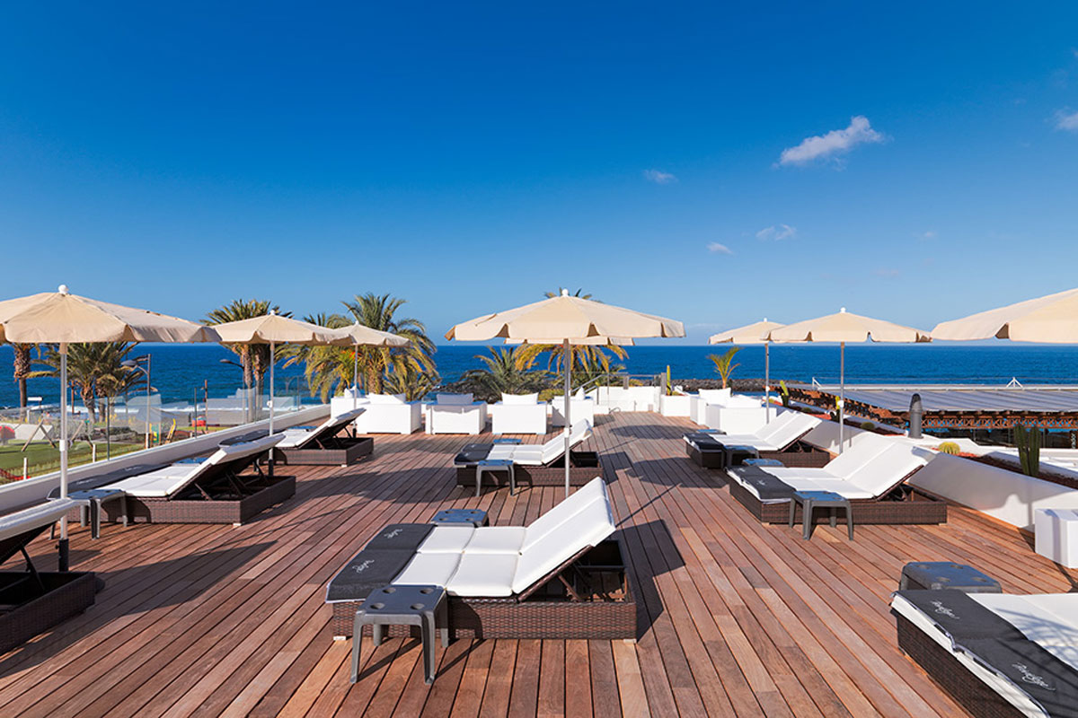 Terrasse avec chaises longues et parasols donnant sur la mer à Tenerife.