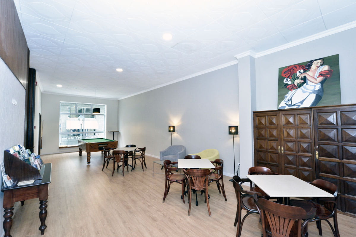 Salle avec tables, chaises et billard à Tenerife, peinture au mur et lampadaires.