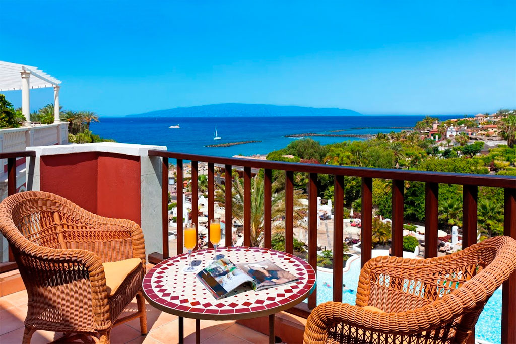 Balcon surplombant la mer avec chaise et table décorée à Tenerife.