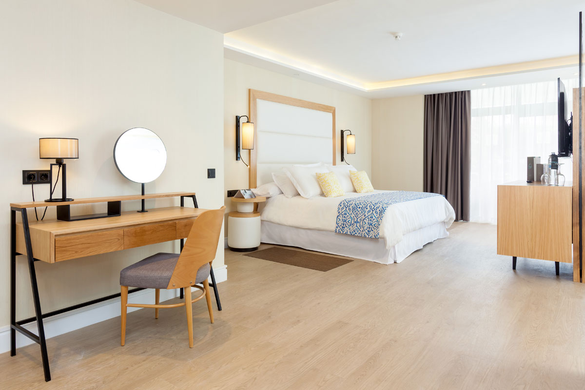 Chambre d'hôtel moderne à Tenerife avec lit double et bureau en bois.