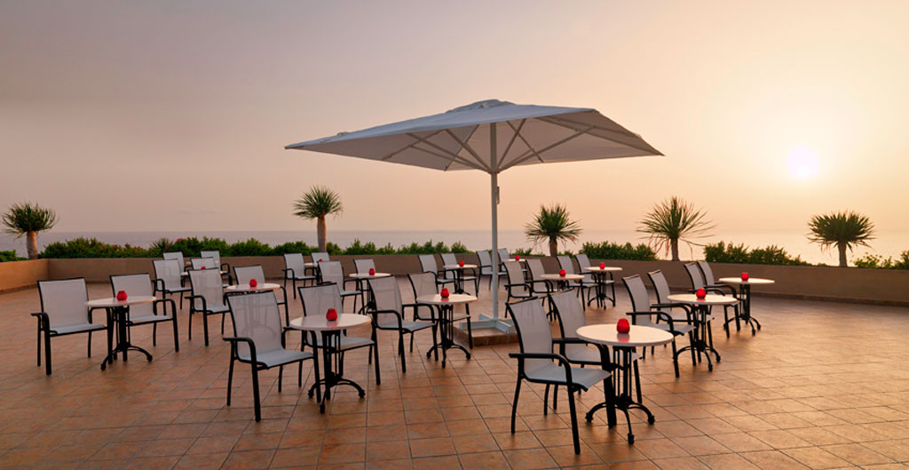 Terrasse avec tables et parasol au coucher du soleil à Tenerife.