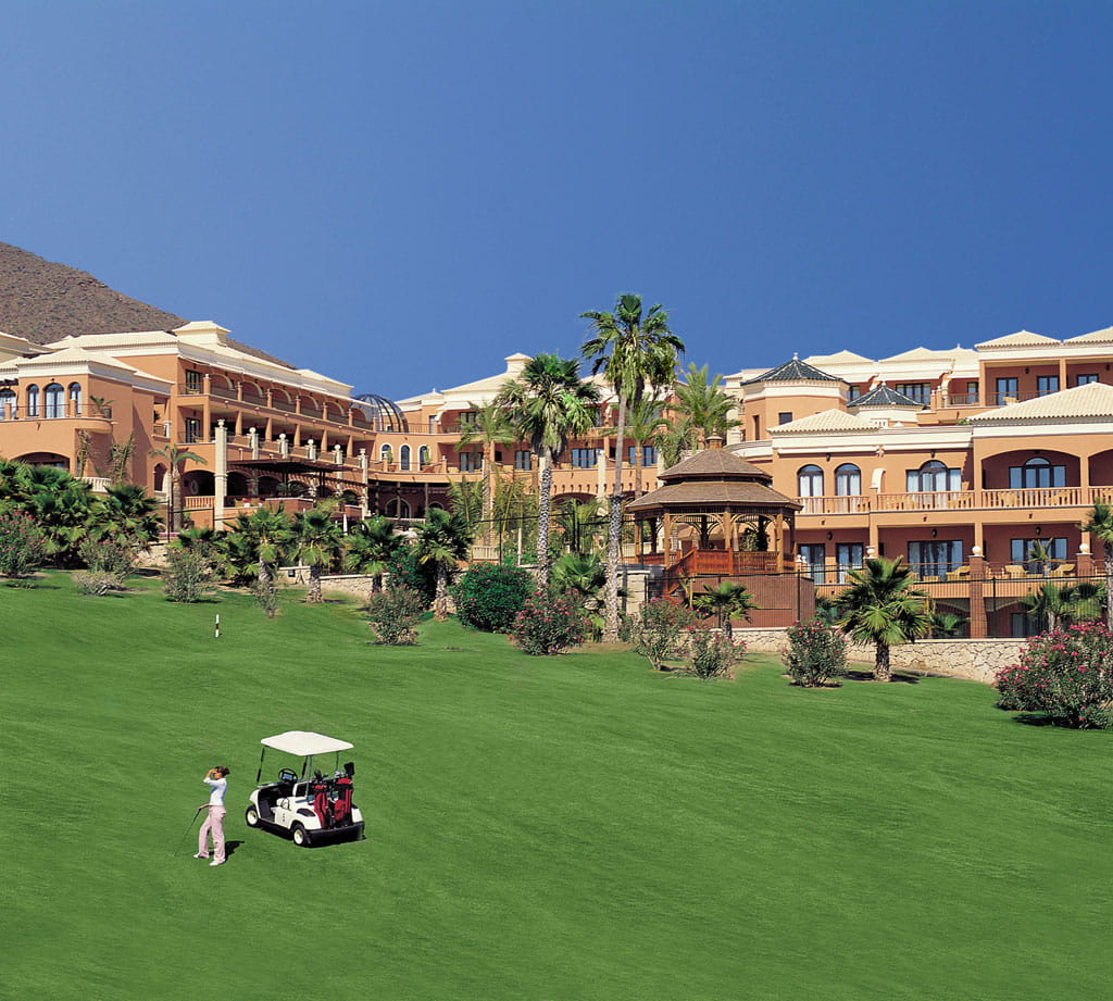 Hôtel à Tenerife avec jardin et voiturette de golf sur gazon vert.