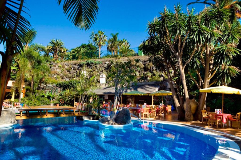 Piscine entourée de palmiers et terrasse à Tenerife.