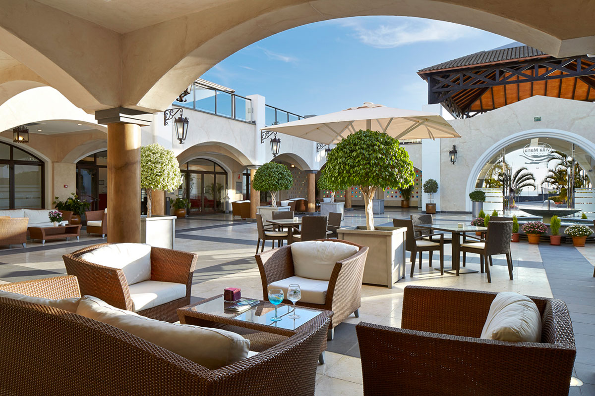 Salon extérieur avec fauteuils en osier et tables, à Tenerife.