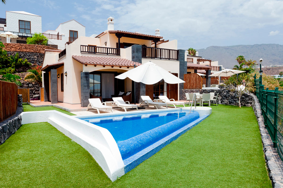 Villa moderne avec piscine et terrasse, Tenerife, entourée de jardins et mobilier de jardin.