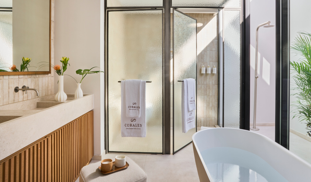 Salle de bain moderne à Corales, Tenerife, avec baignoire, douche et serviette blanche.