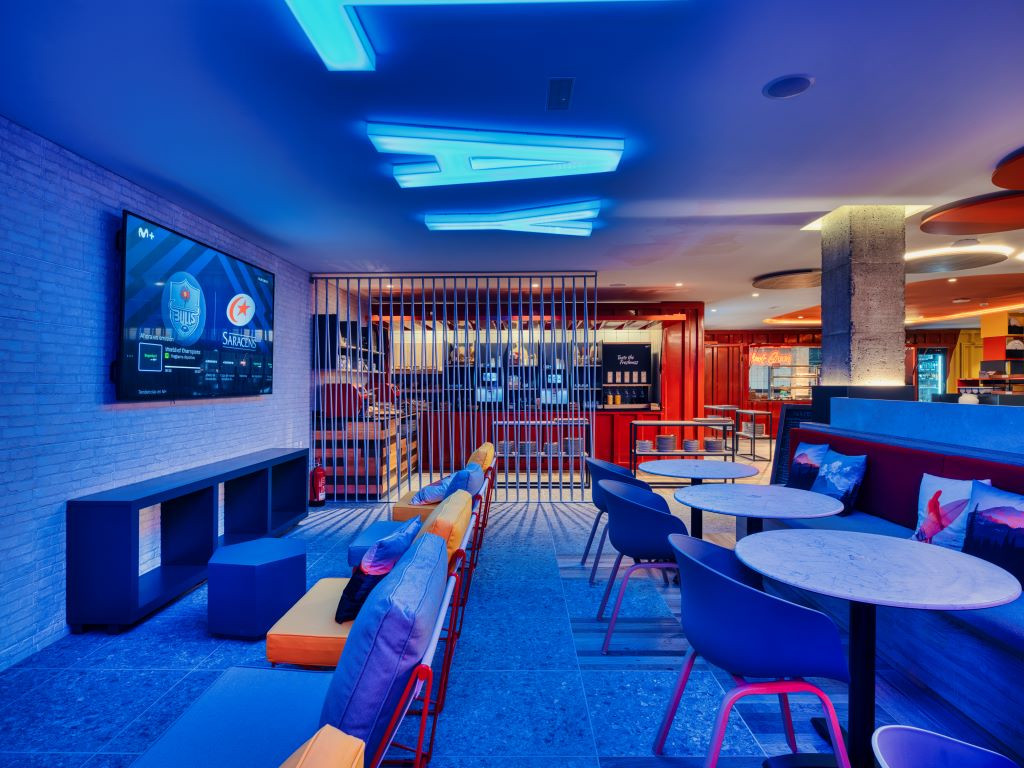 Aire de repos éclairée à Tenerife bar avec écran et tables.