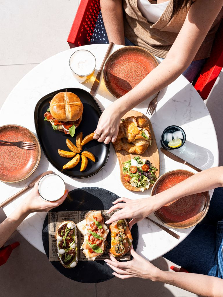 Table avec hamburger, frites, salade et boissons dans un restaurant à Tenerife.