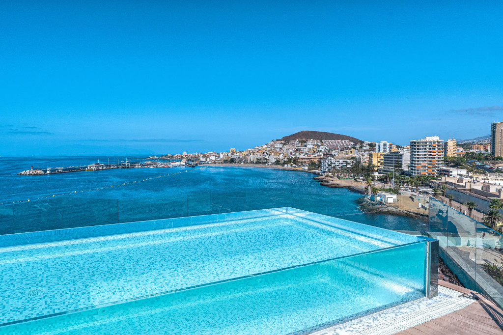 Vue sur la piscine à débordement avec la côte de Tenerife en arrière-plan.