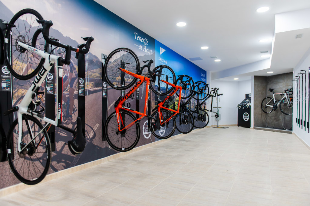 Bicyclettes accrochées au mur d'un magasin à Tenerife, fond avec montagnes.