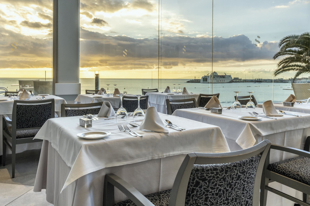 Tables dressées avec vue sur la mer au coucher de soleil à Santa Cruz de Tenerife.