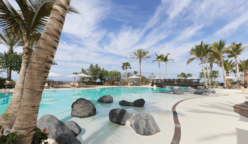 Piscine extérieure avec palmiers et rochers à Tenerife.