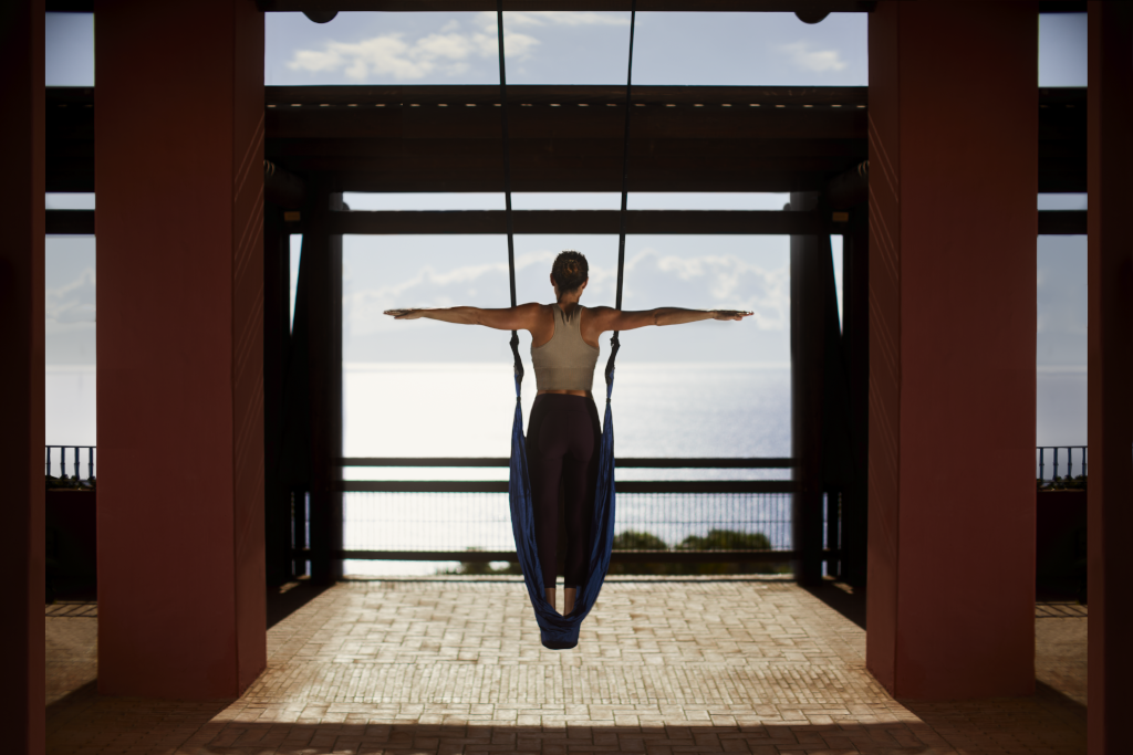 Personne faisant du yoga aérien avec vue sur l'océan à Tenerife.
