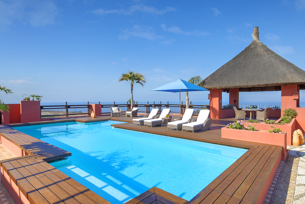 Piscine extérieure avec chaises longues et vue sur la mer à Tenerife.