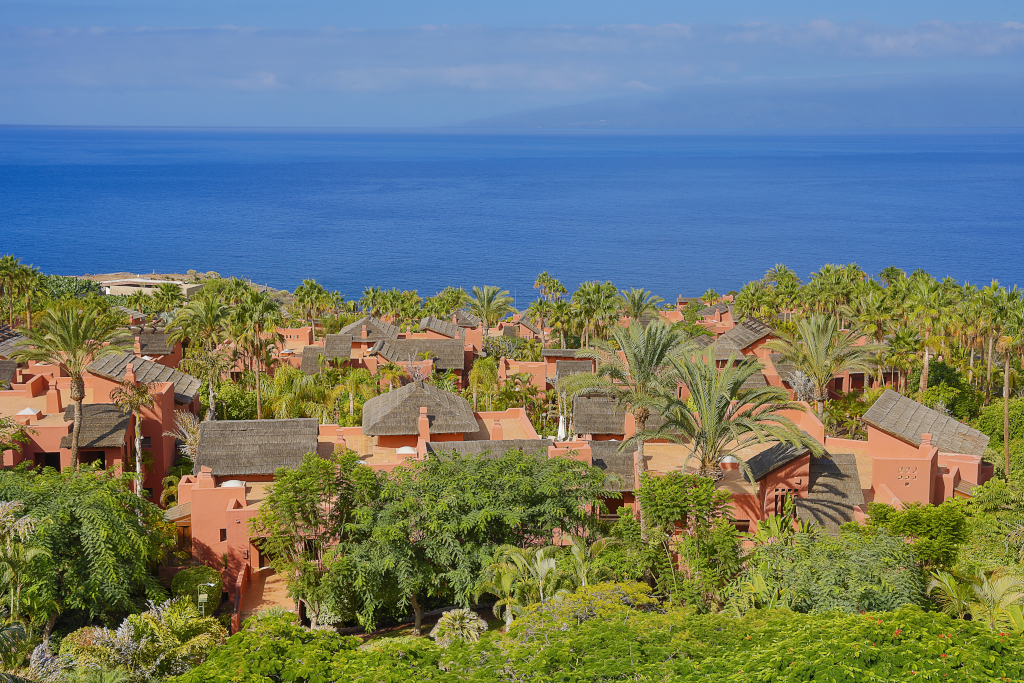 Vue sur villas et palmiers avec l'océan à Tenerife.