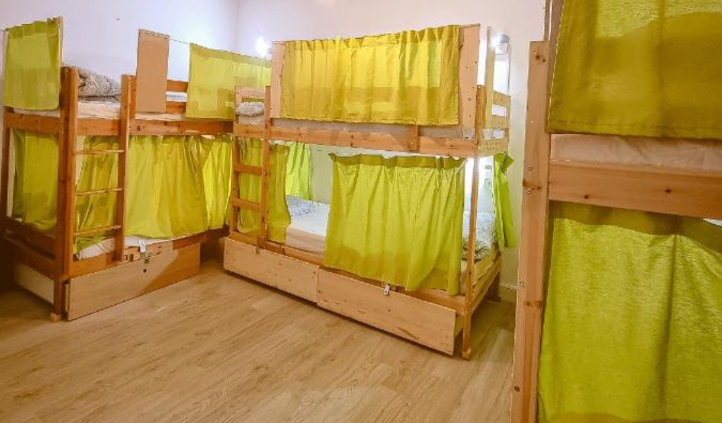Dortoir avec lits superposés et rideaux verts à Tenerife.