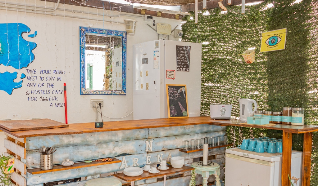Comptoir d'accueil avec théière, tasses et écriteau au Tenerife Hostel.