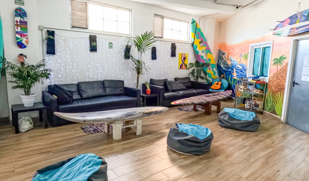 Salon avec canapés, planches de surf et mur coloré à Tenerife.