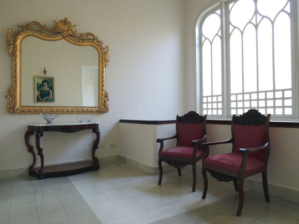 Deux fauteuils rouges et un miroir doré dans une salle lumineuse à Tenerife.