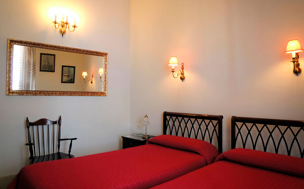 Chambre avec deux lits simples et chaises en bois à Tenerife.