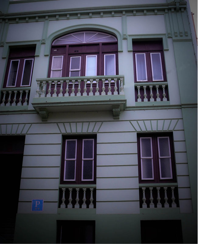 Façade d'un bâtiment à La Laguna, Tenerife, avec un balcon et fenêtres en bois.
